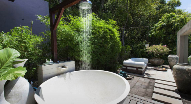 outdoor-bathroom-in-the-garden-with-white-round-bathtub-shower-heads-vanities-plus-chaise-lounge-sofa-bed-and-laminate-wooden-flooring